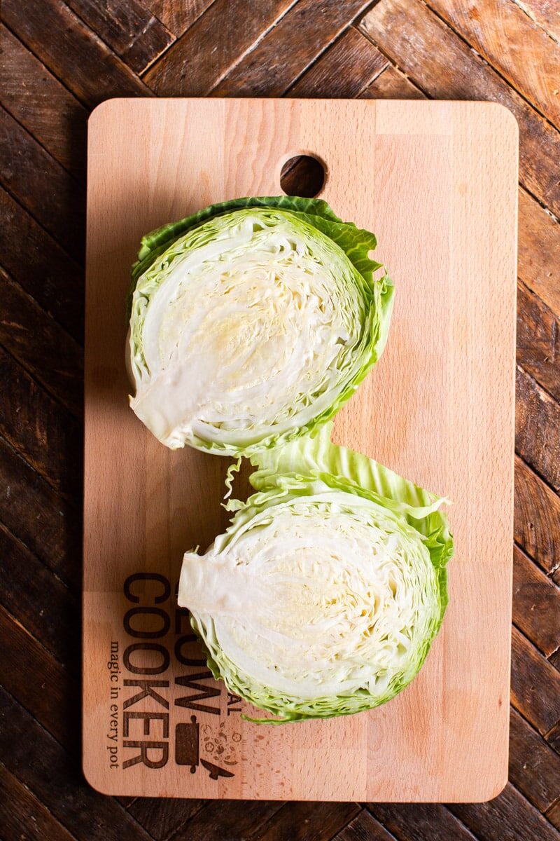 A split head of cabbage on a cutting board.