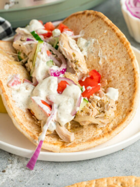 chicken gyro on plate in front of a slow cooker.