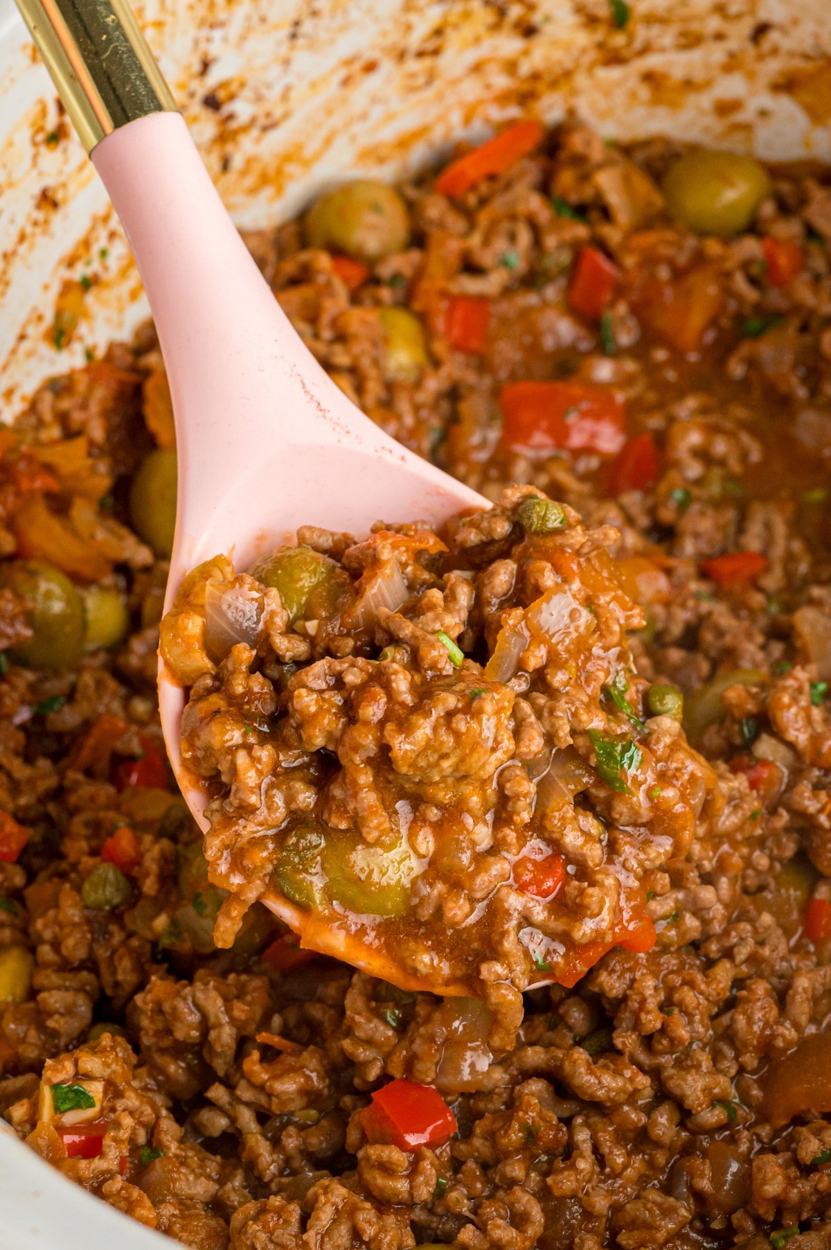 A ladle scooping out some slow cooker picadillo.