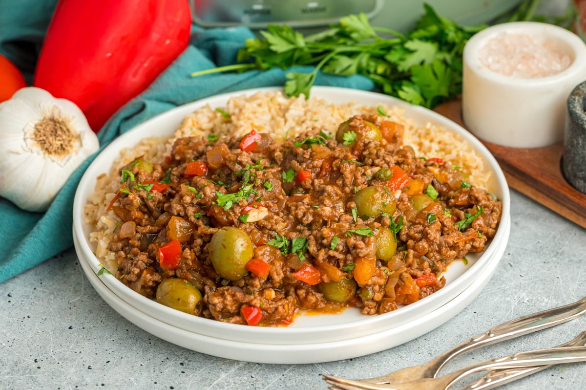 A serving of slow cooker picadillo and rice on a white plate.