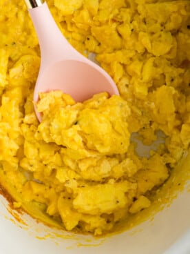 A spoon scooping out some slow cooker scrambled eggs.