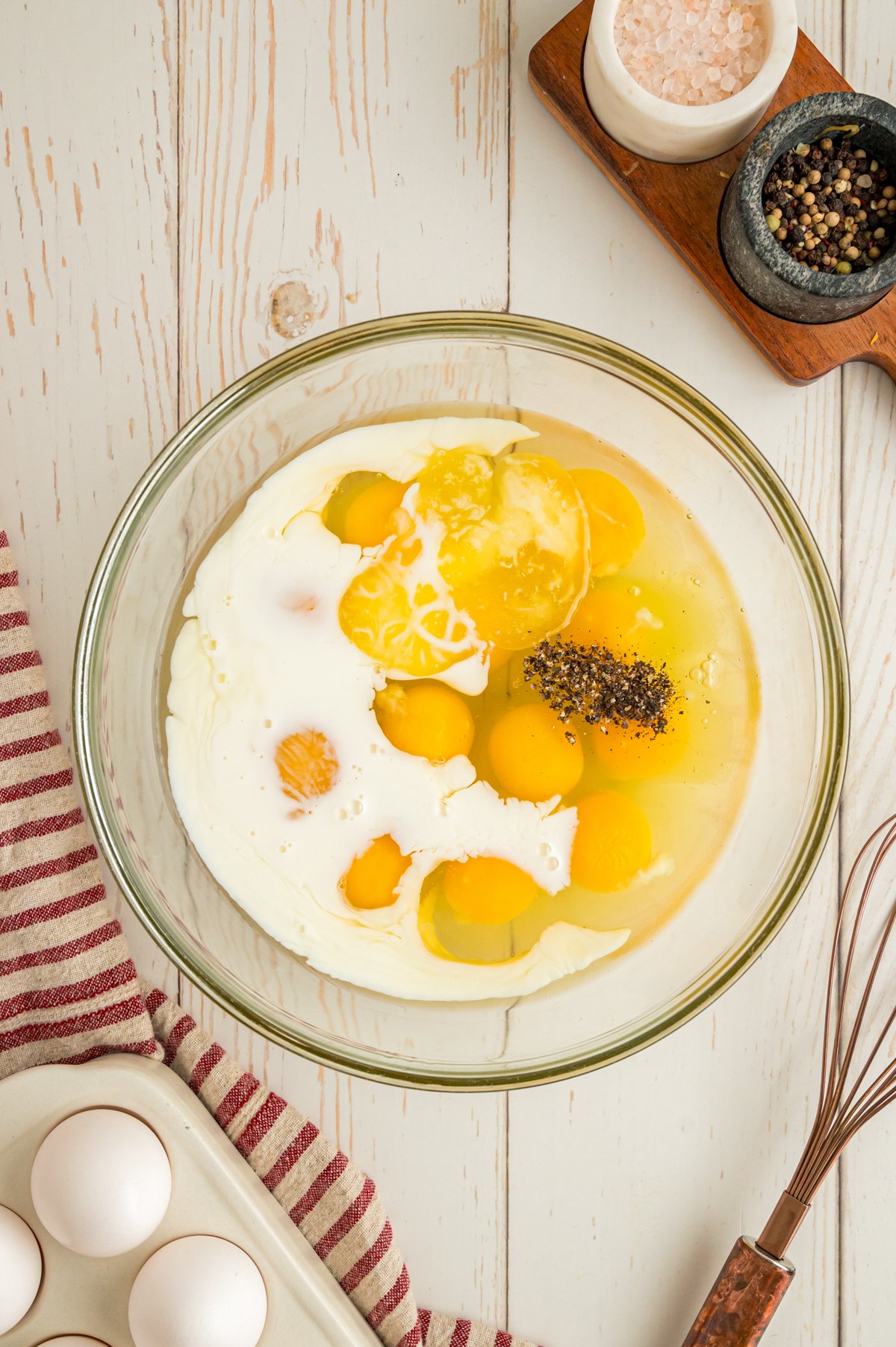 Ingredients for slow cooker scrambled eggs in a mixing bowl.