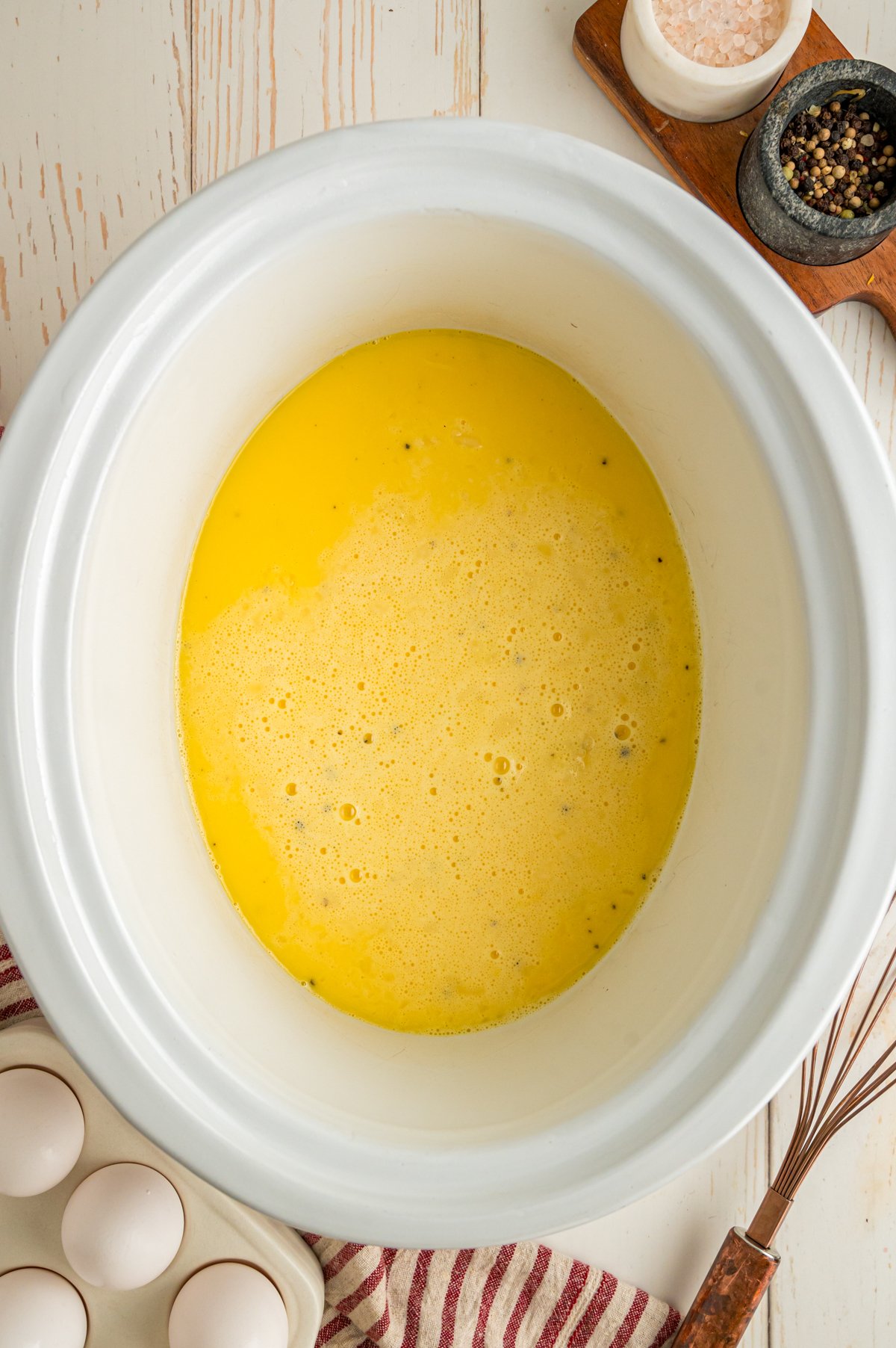 Whisked ingredients for scrambled eggs in a slow cooker.