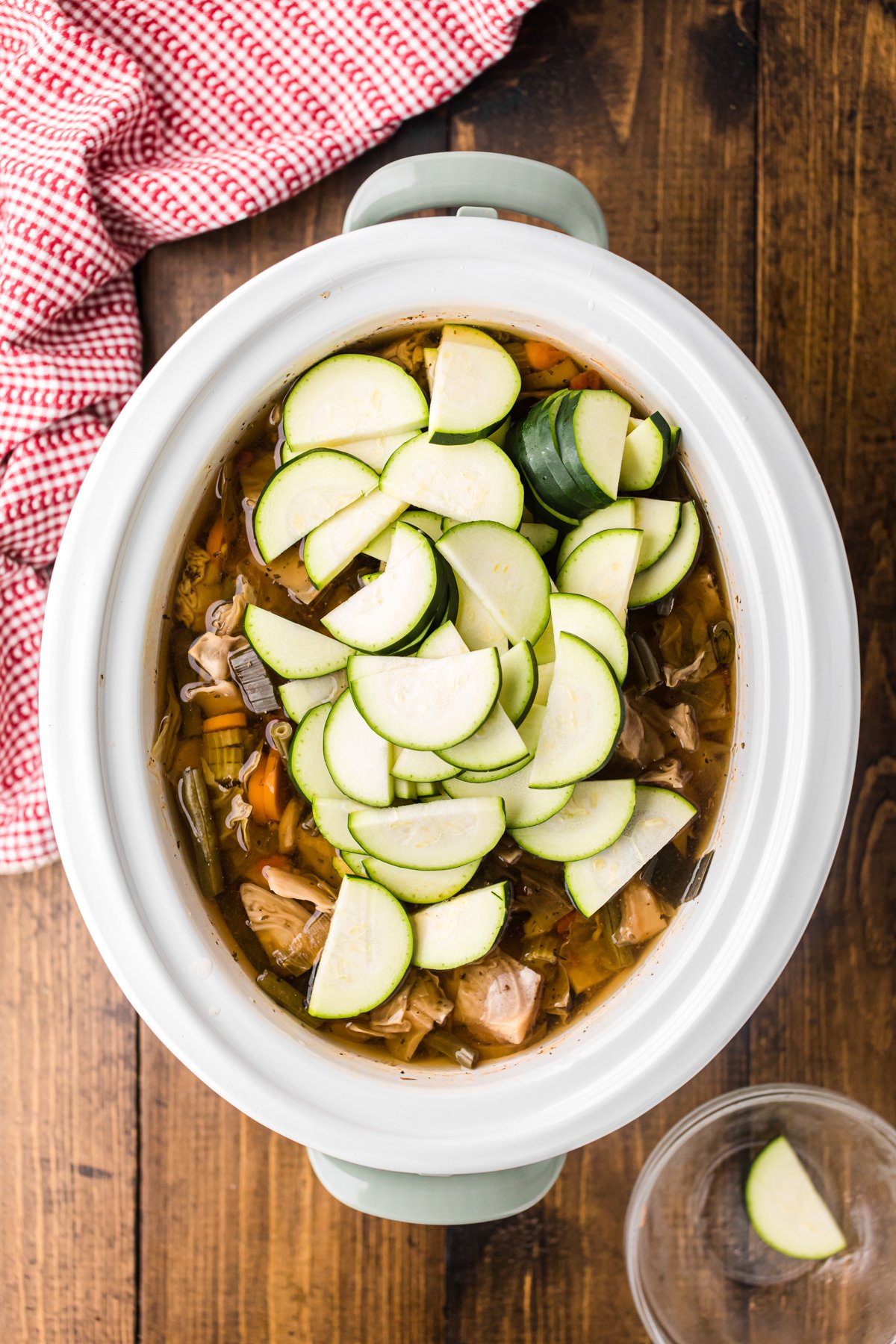 Zucchini added to cooked soup in a crockpot.