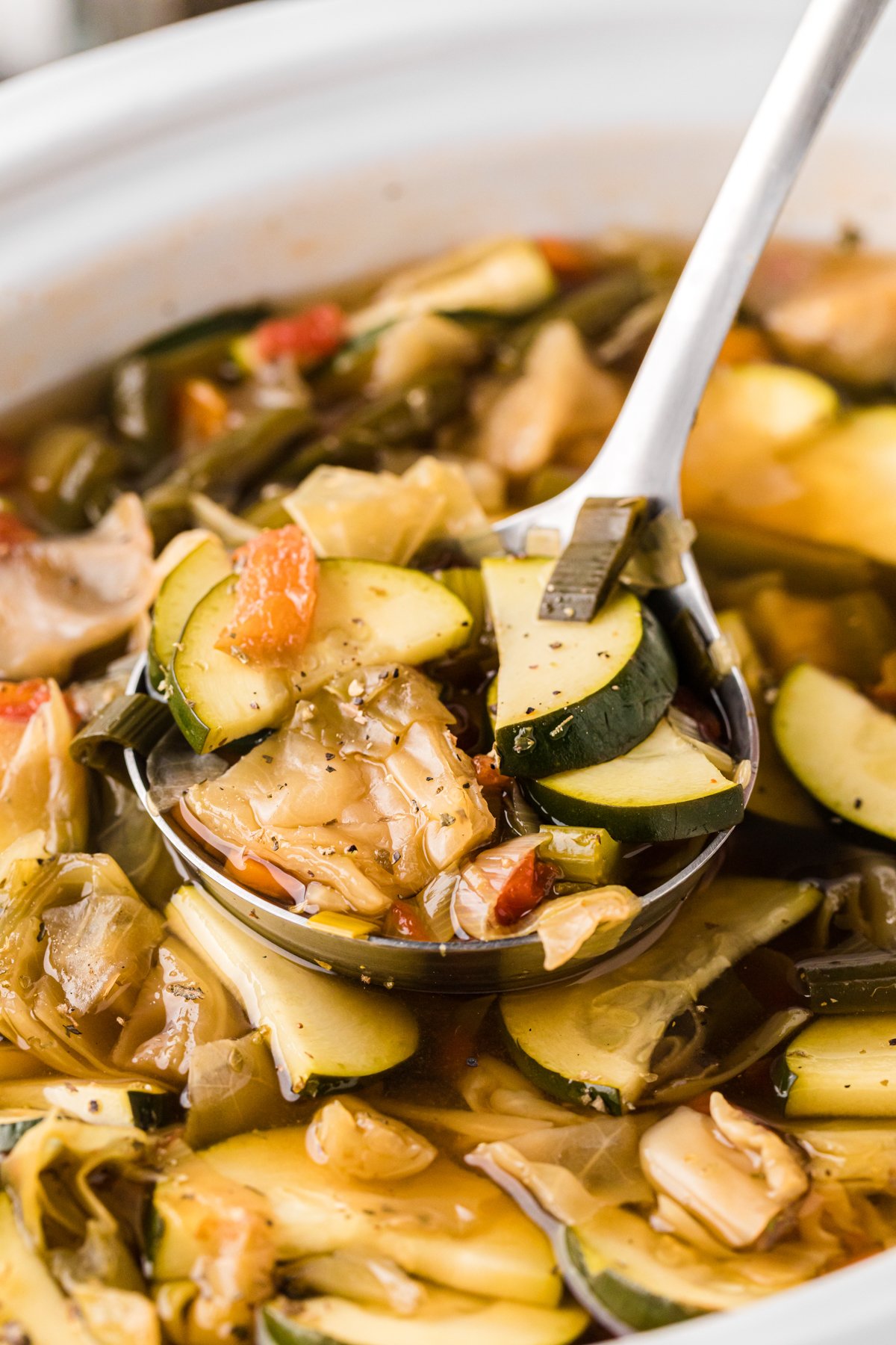 Close-up of slow cooker weight loss soup with a ladle.
