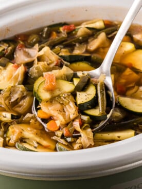 A ladle scooping out some slow cooker weight loss soup.