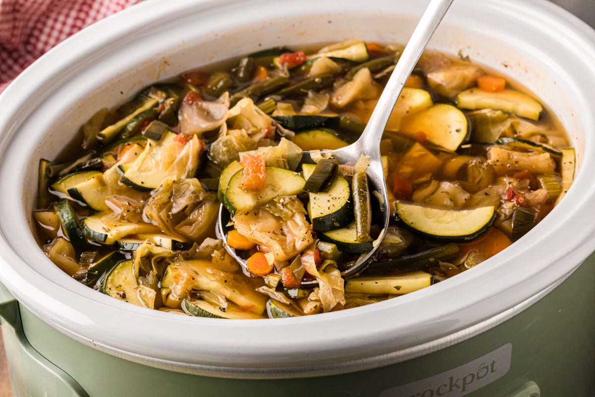 A ladle scooping out some slow cooker weight loss soup.