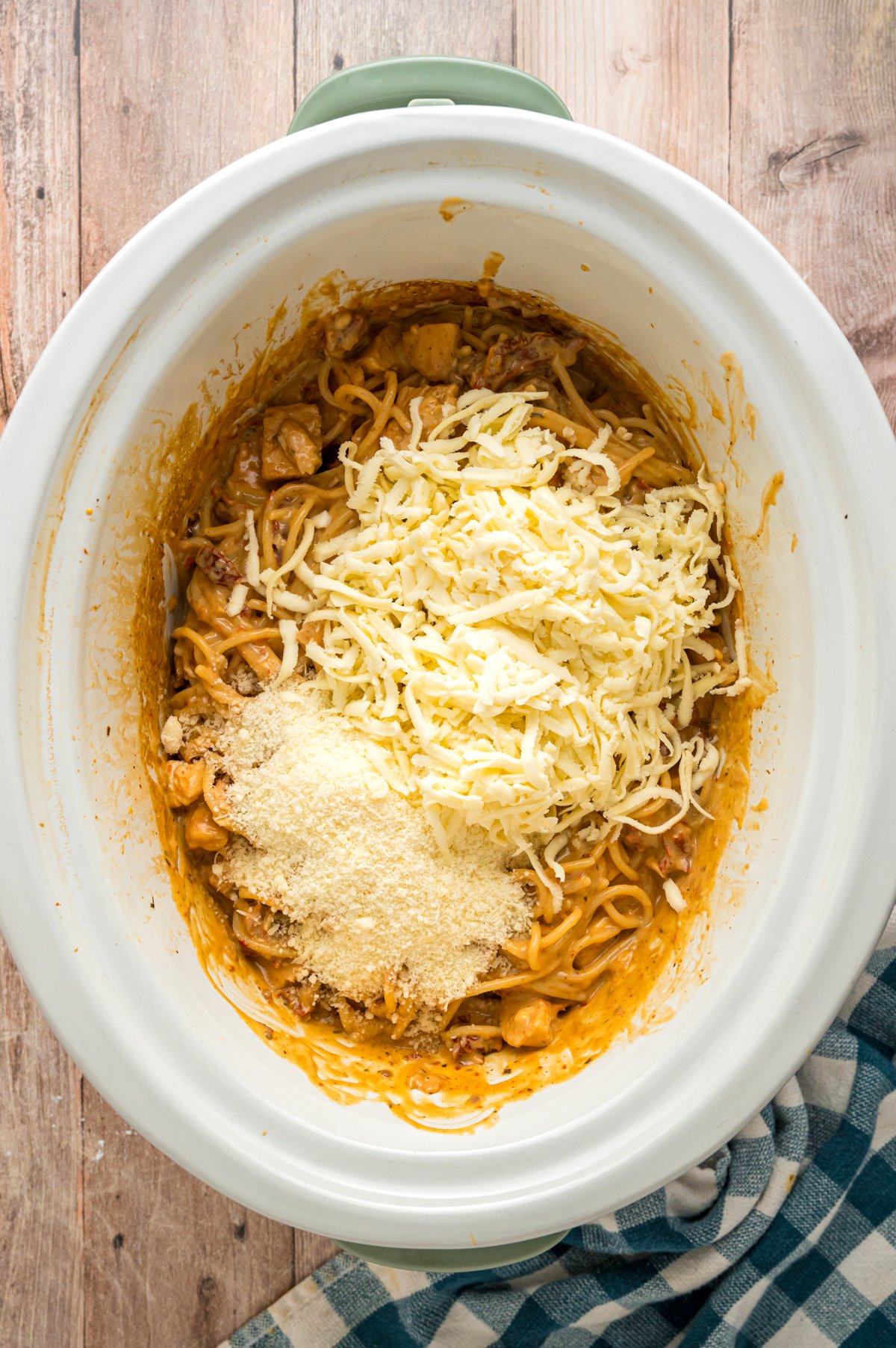 Parmesan and mozzarella cheese added to a crockpot.