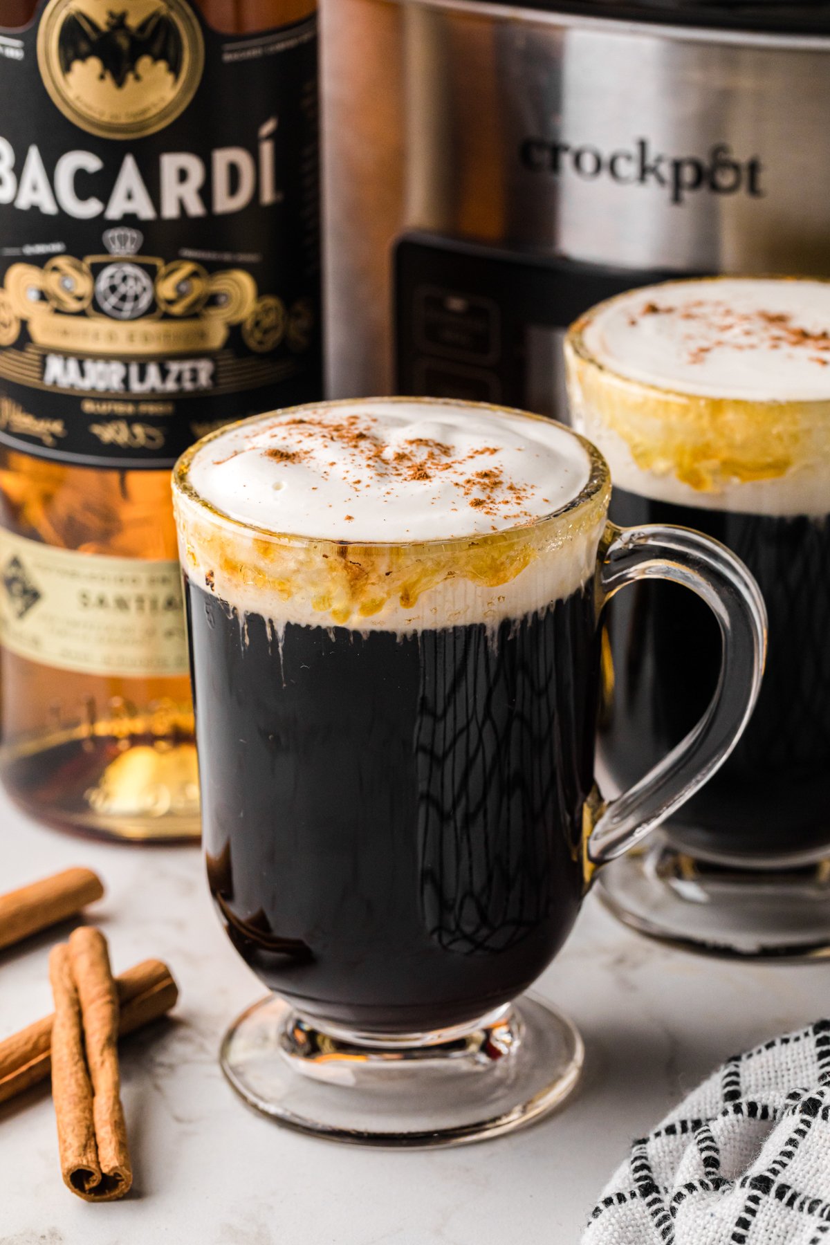 Slow cooker spanish coffee in a glass mug with another behind it.