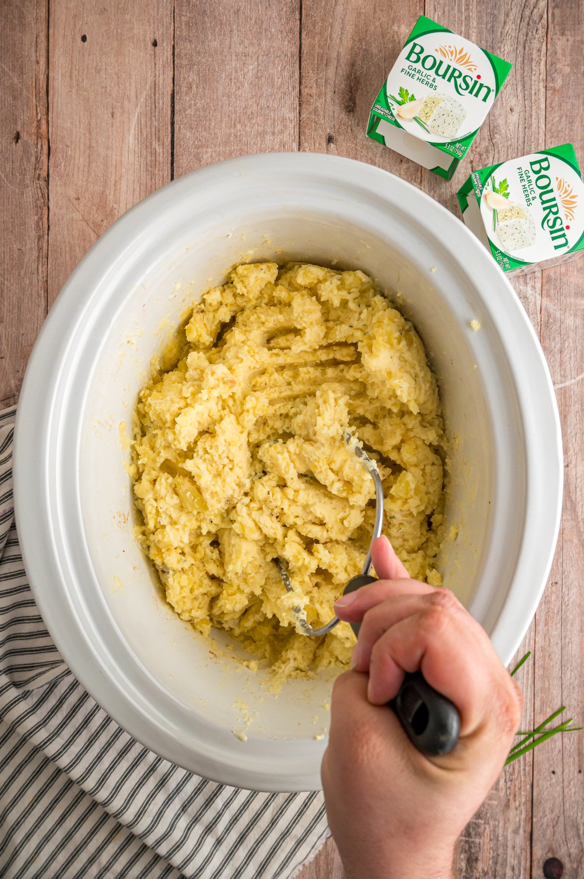 Mashing potatoes in a crockpot.