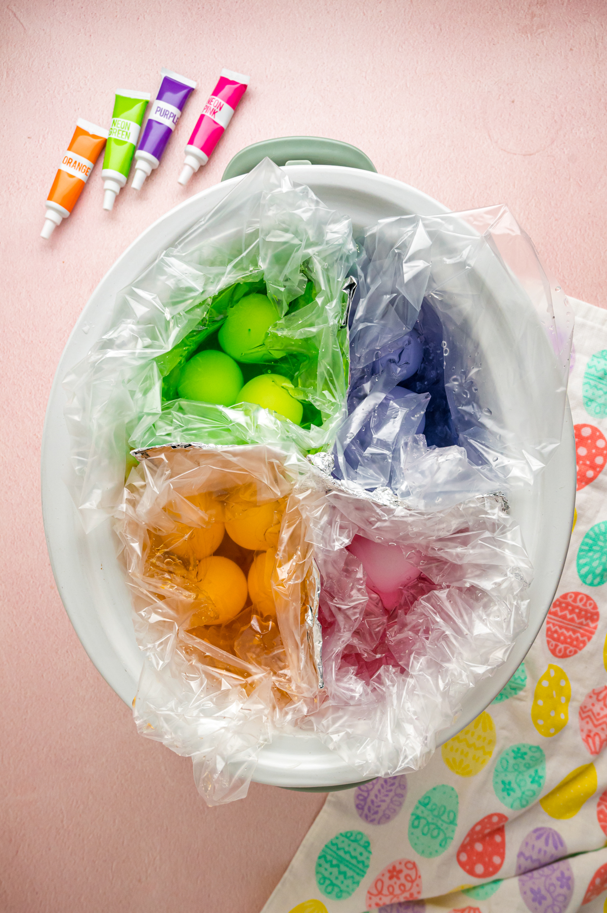 Colored easter eggs in a crockpot before cooking.