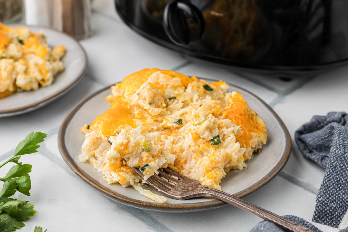 Slow cooker party potatoes on a plate with a fork.