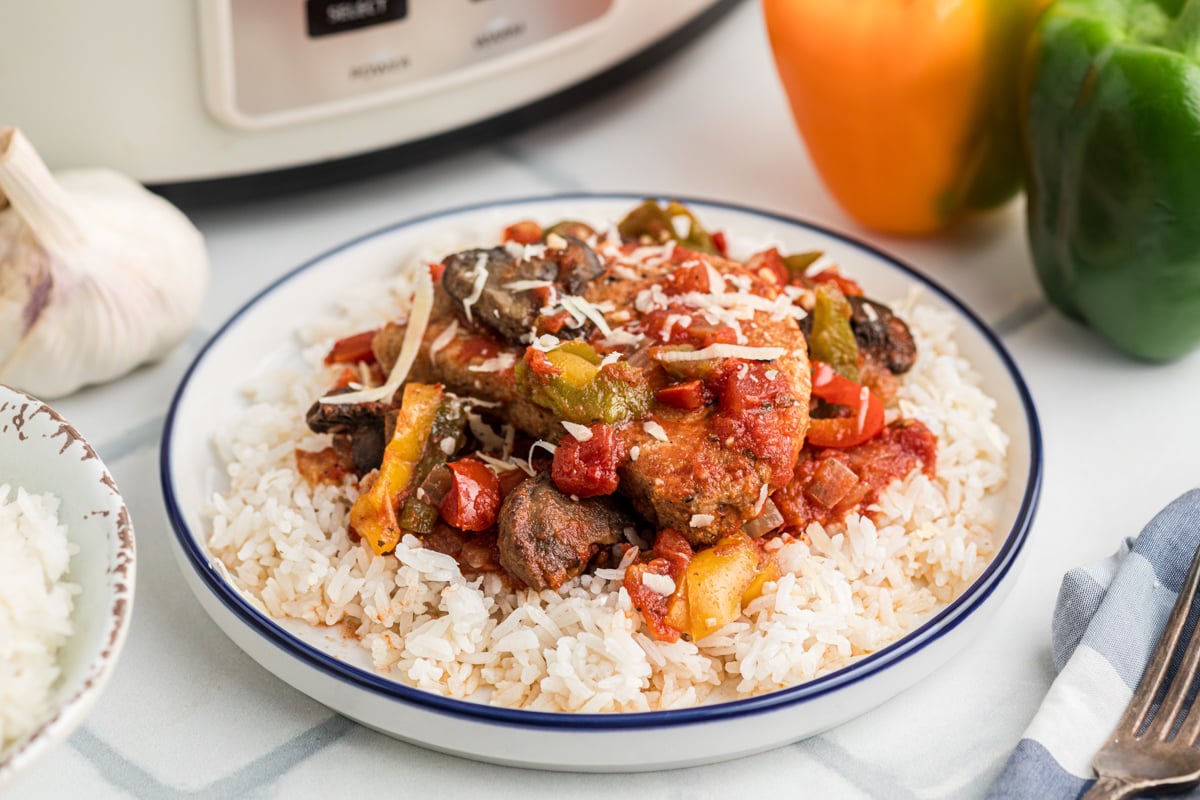 Slow cooker pork chop cacciatore on a plate with rice.