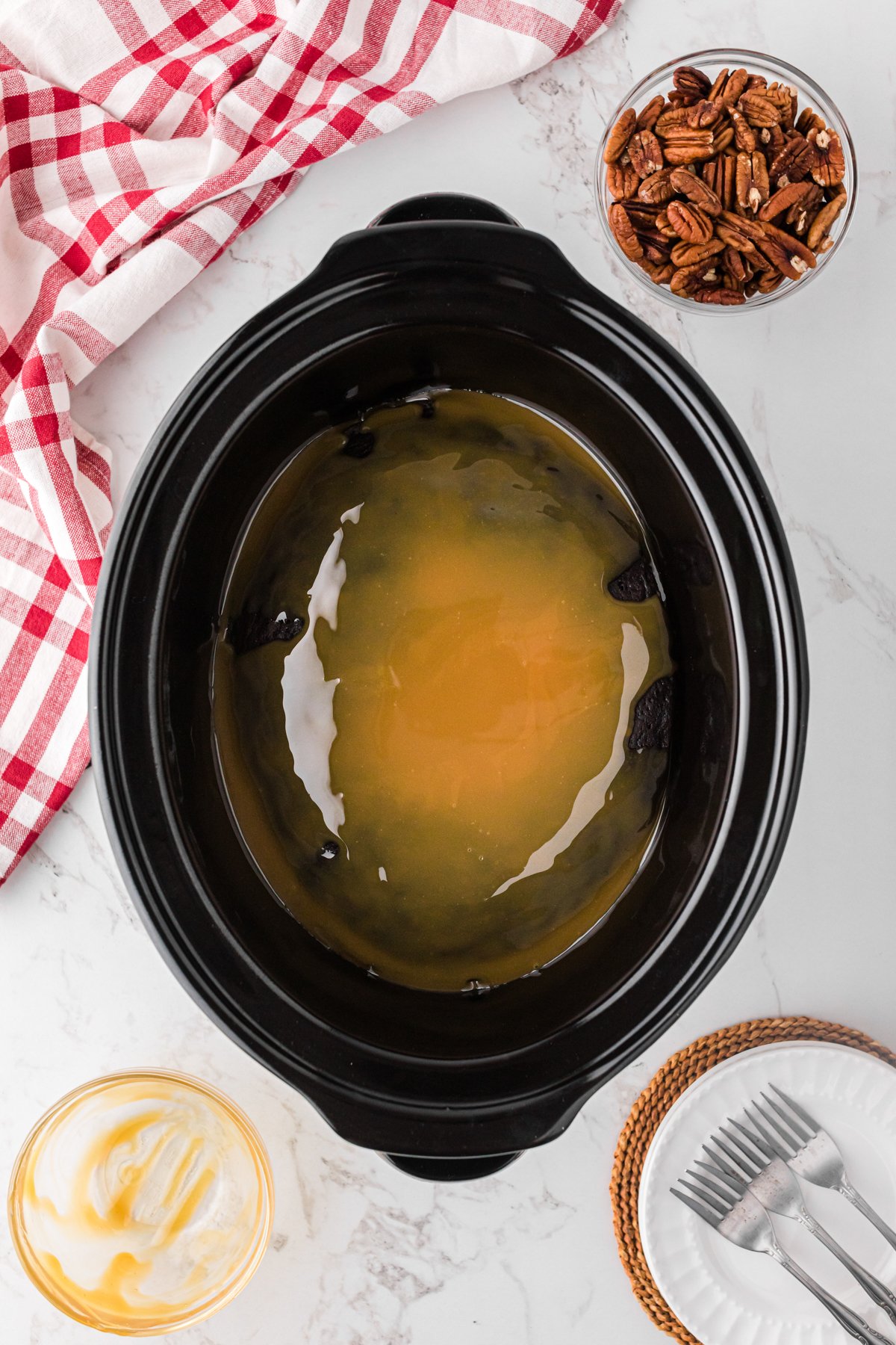 Salted caramel on top of a baked cake in a crockpot.