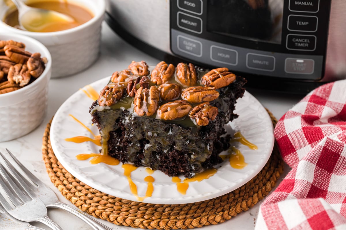 A plate holding a slice of slow cooker turtle cake.