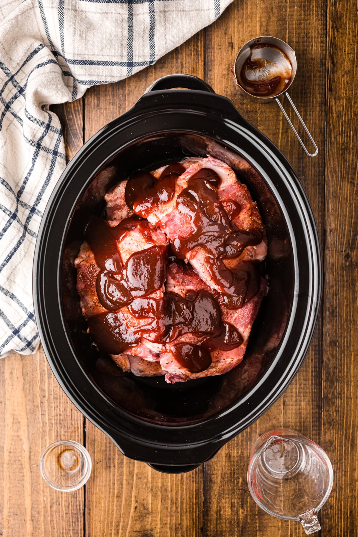 Seasoned ribs, liquid smoke, and bbq sauce in a slow cooker.