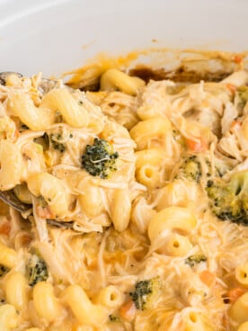 A spoon scooping out some slow cooker chicken broccoli pasta.