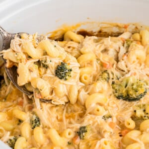 A spoon scooping out some slow cooker chicken broccoli pasta.