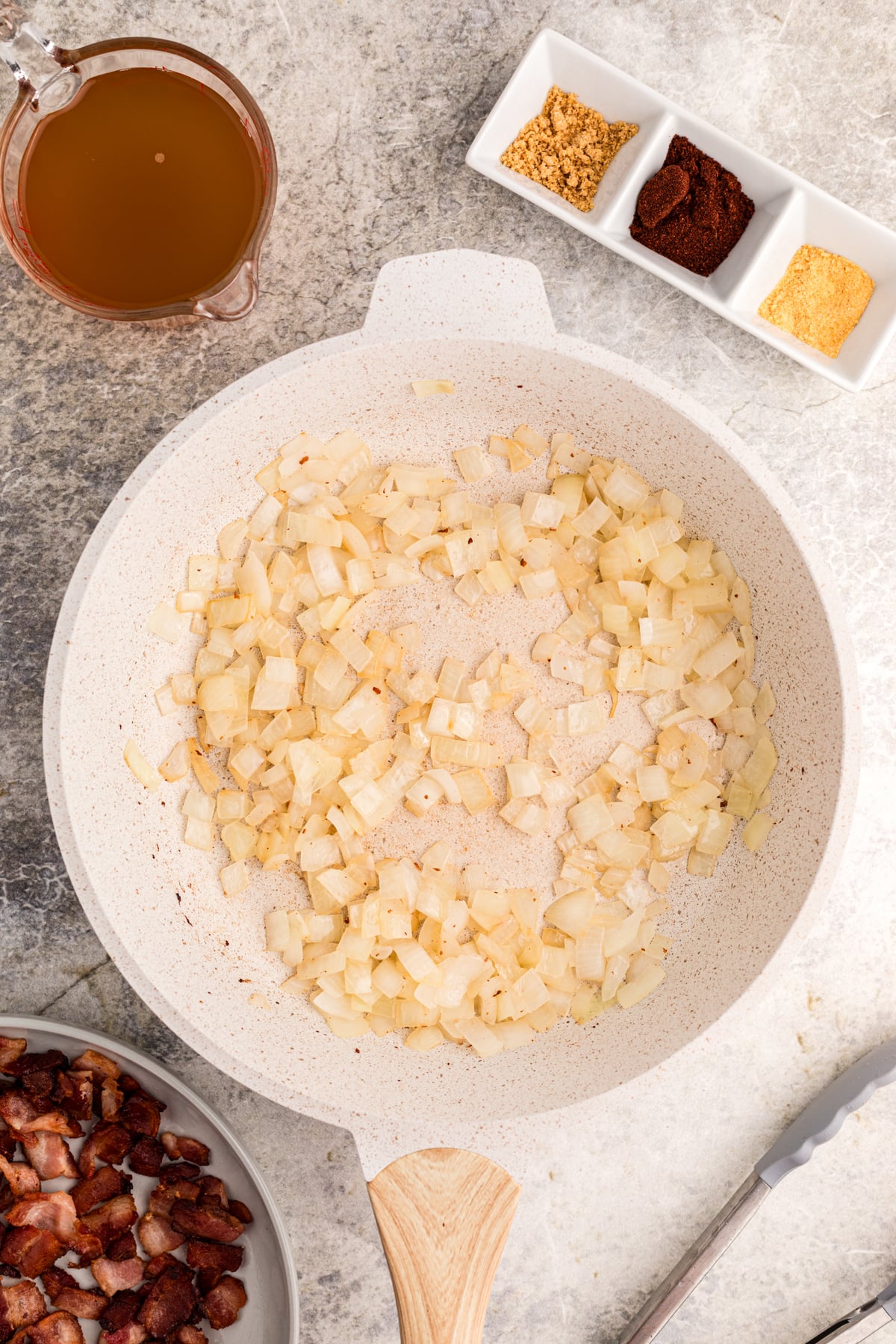 Onion cooking in baocn grease in a skillet.