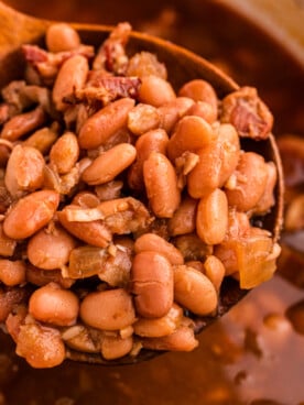 A large scoop of slow cooker pinto beans on a spoon.