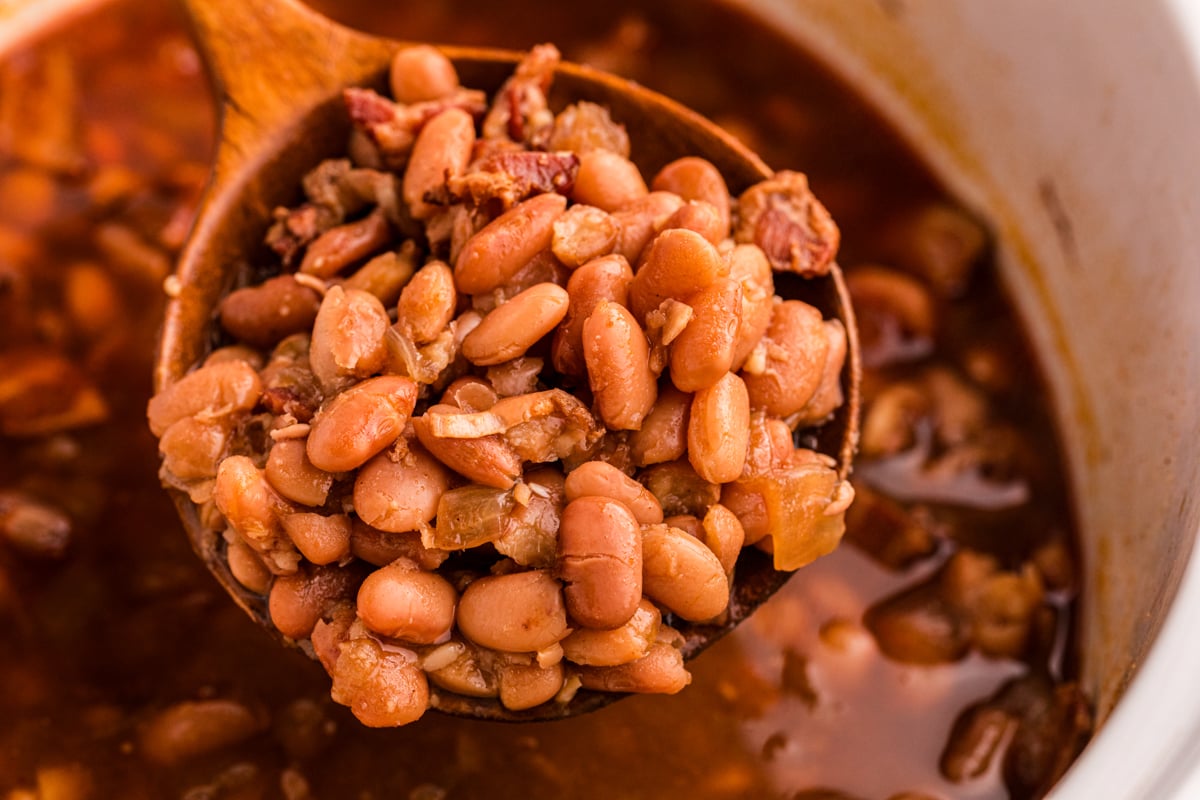 A large scoop of slow cooker pinto beans on a spoon.