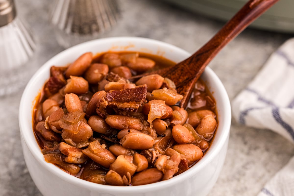 A serving of slow cooker pinto beans in a bowl with a spoon.