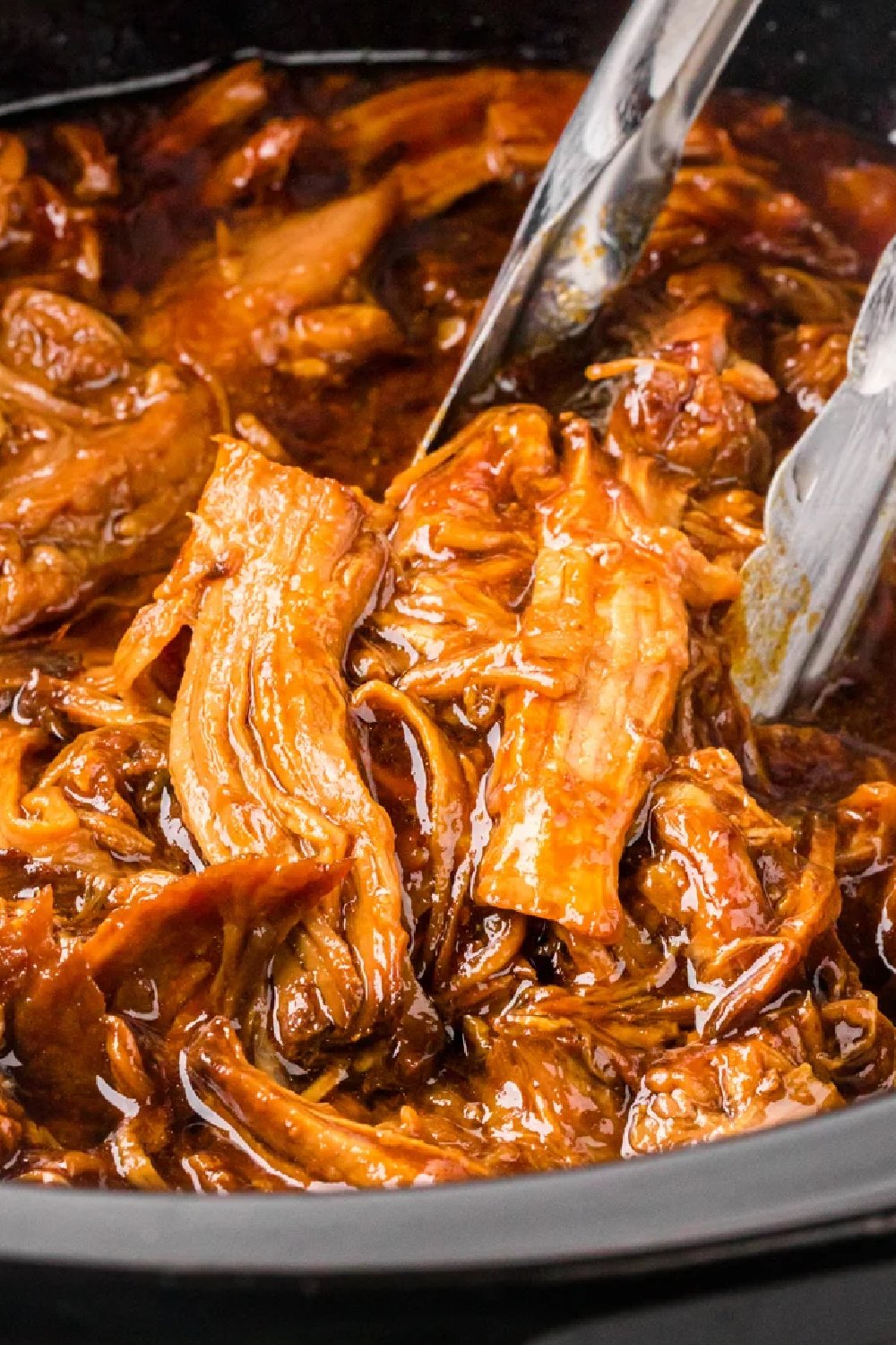close up of root beer puleld pork in a slow cooker.