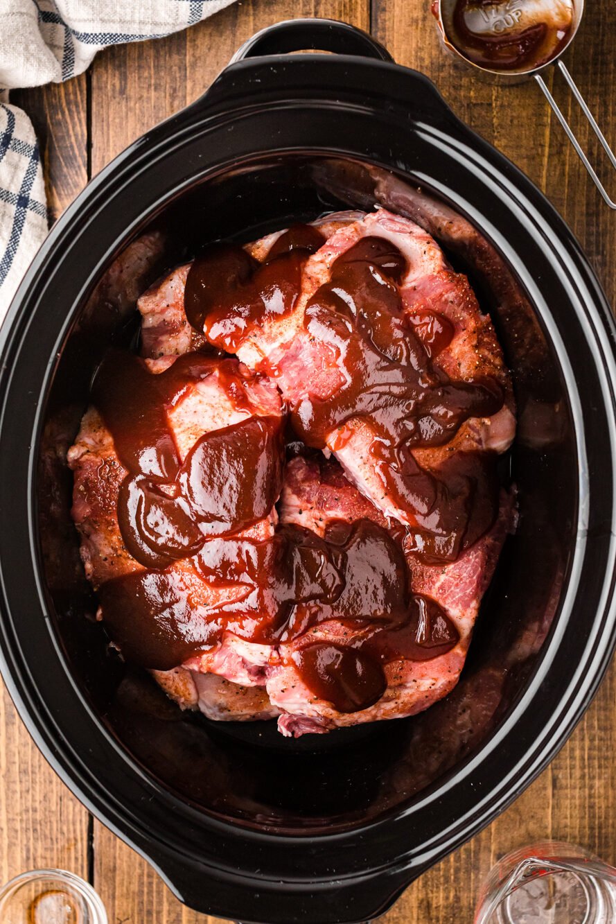 Seasoned ribs, liquid smoke, and bbq sauce in a slow cooker.
