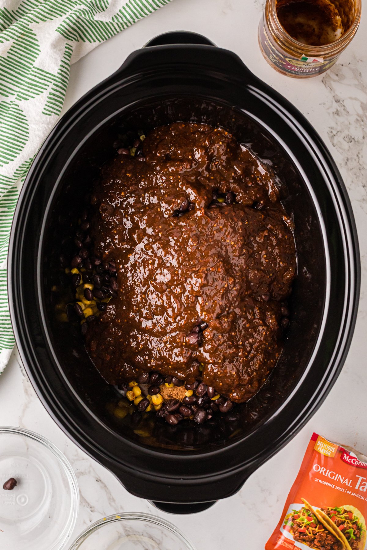 Chipotle salsa added to other ingredients in a crockpot.