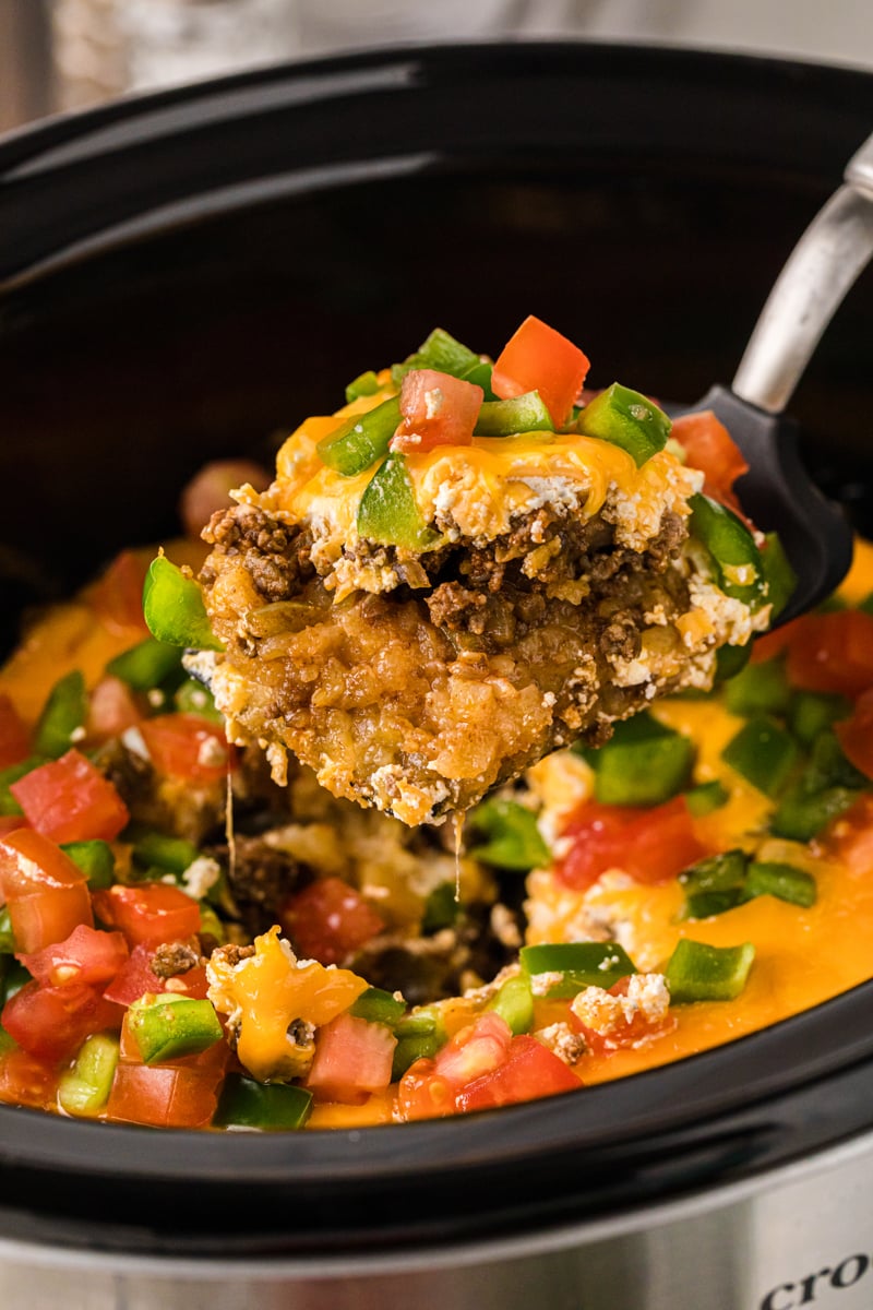 A scoop of John Wayne casserole being scooped out of a crockpot.