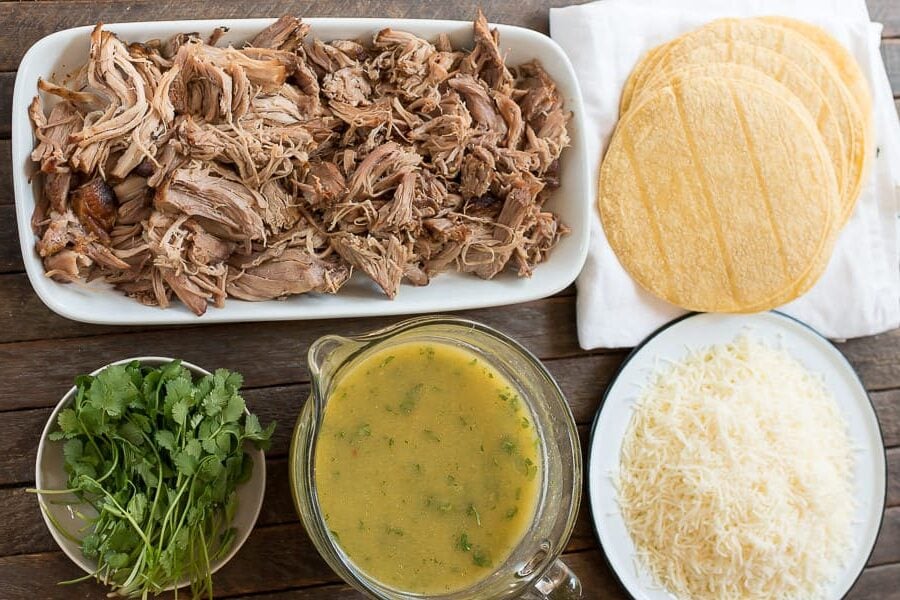 shredded pork, green enchilada sauce, cheese, corn tortillas and cilantro in dishes.