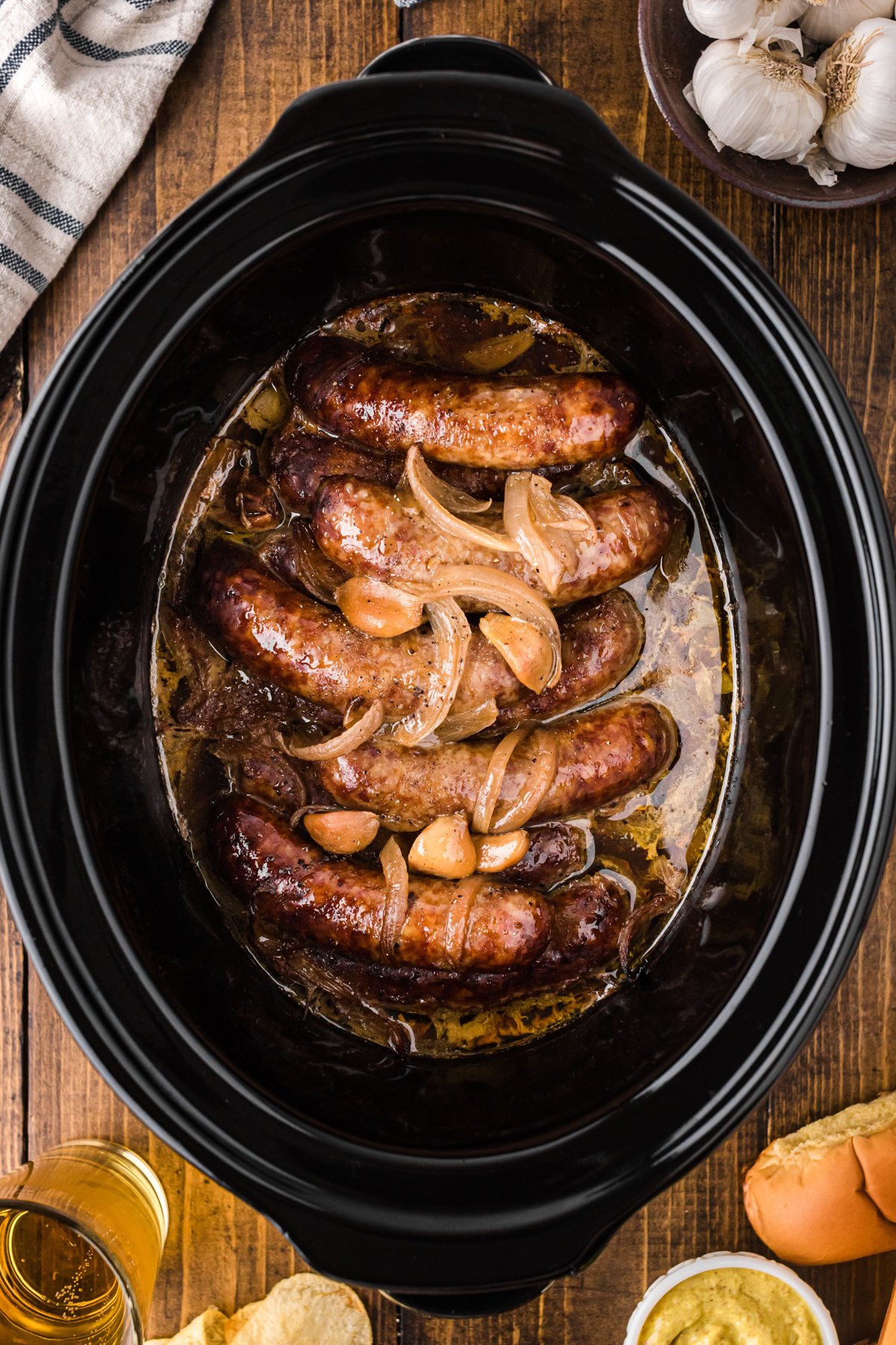 cooked beer brats in a slow cooker in a buttery sauce.