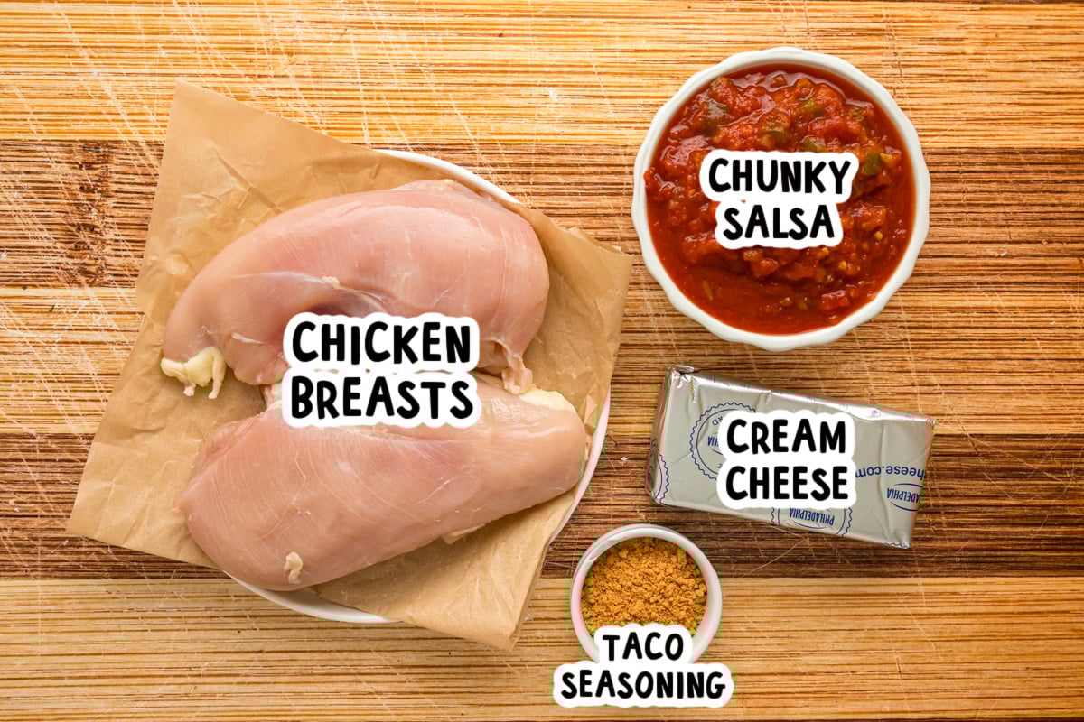 Ingredients for slow cooker creamy salsa chicken on a table.