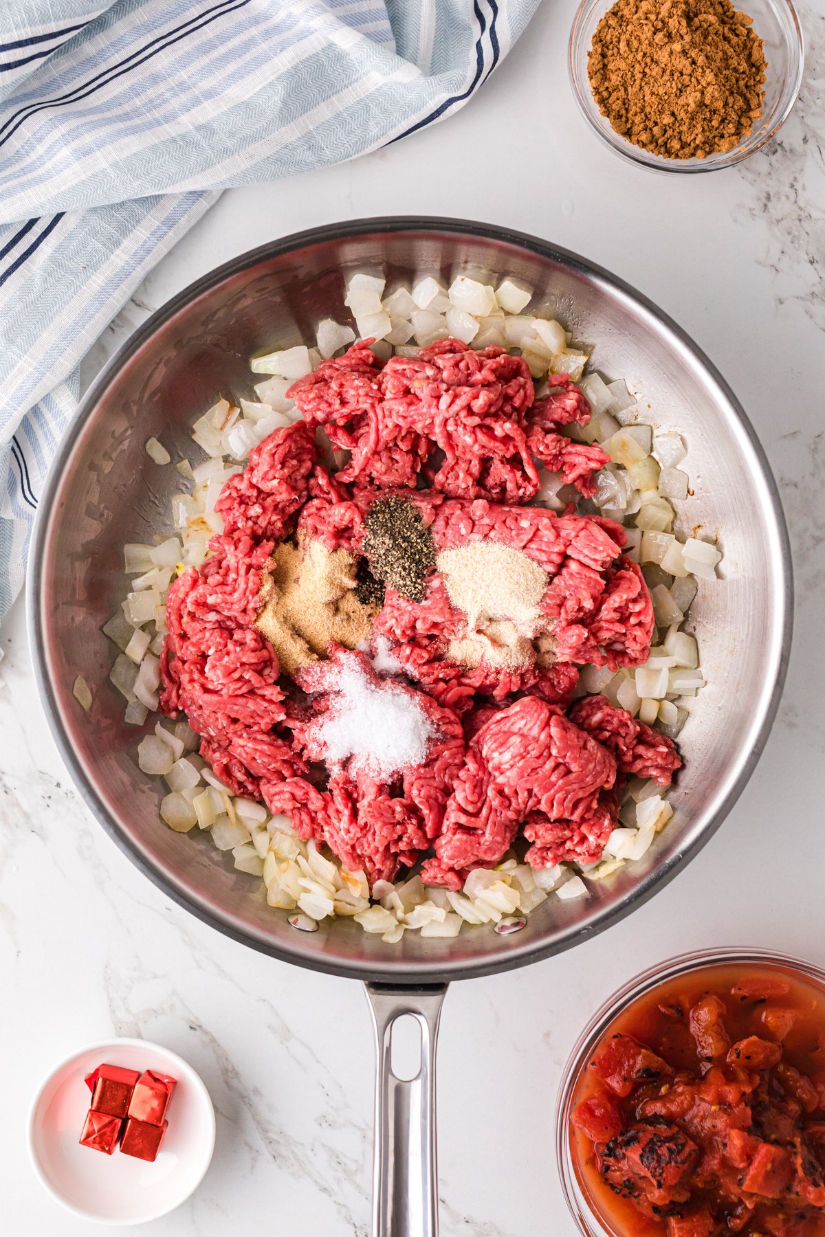 Ground beef, onion, and seasonings in a skillet.