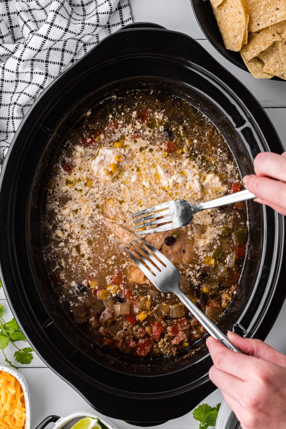 chicken being shreded in chicken fajita soup.