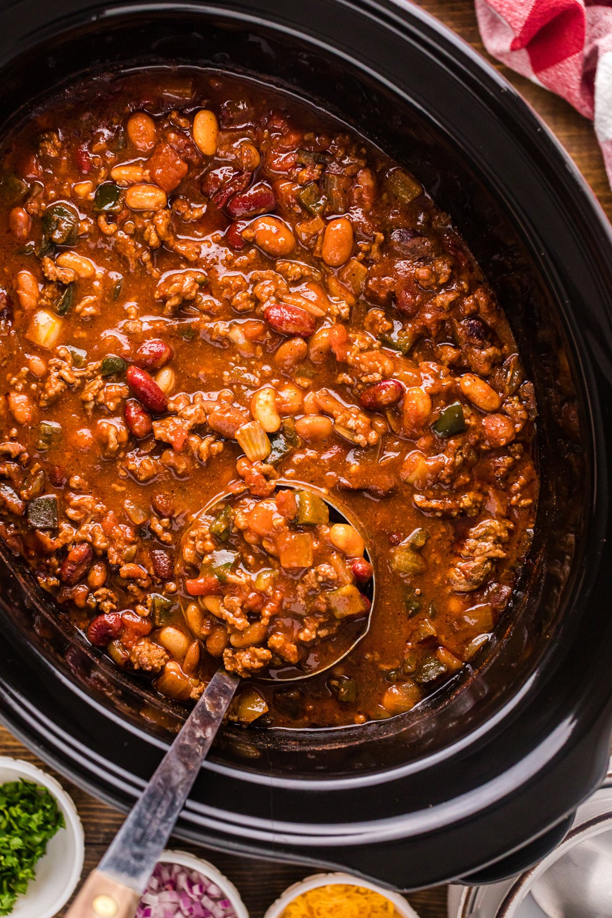 A crockpot of cowboy chili with a ladle in it.