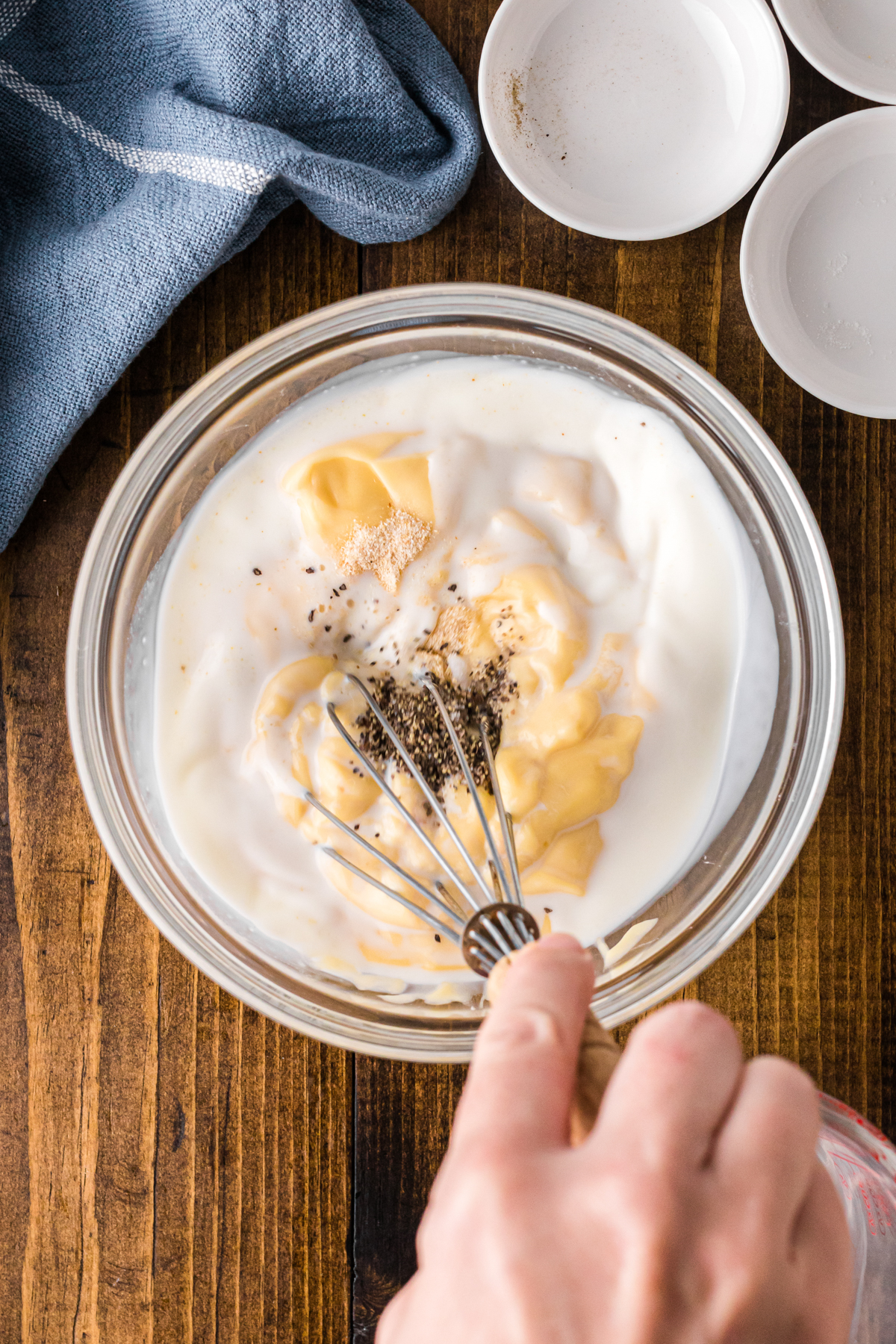Whisking cream soup, milk, and seasonings in a bowl.