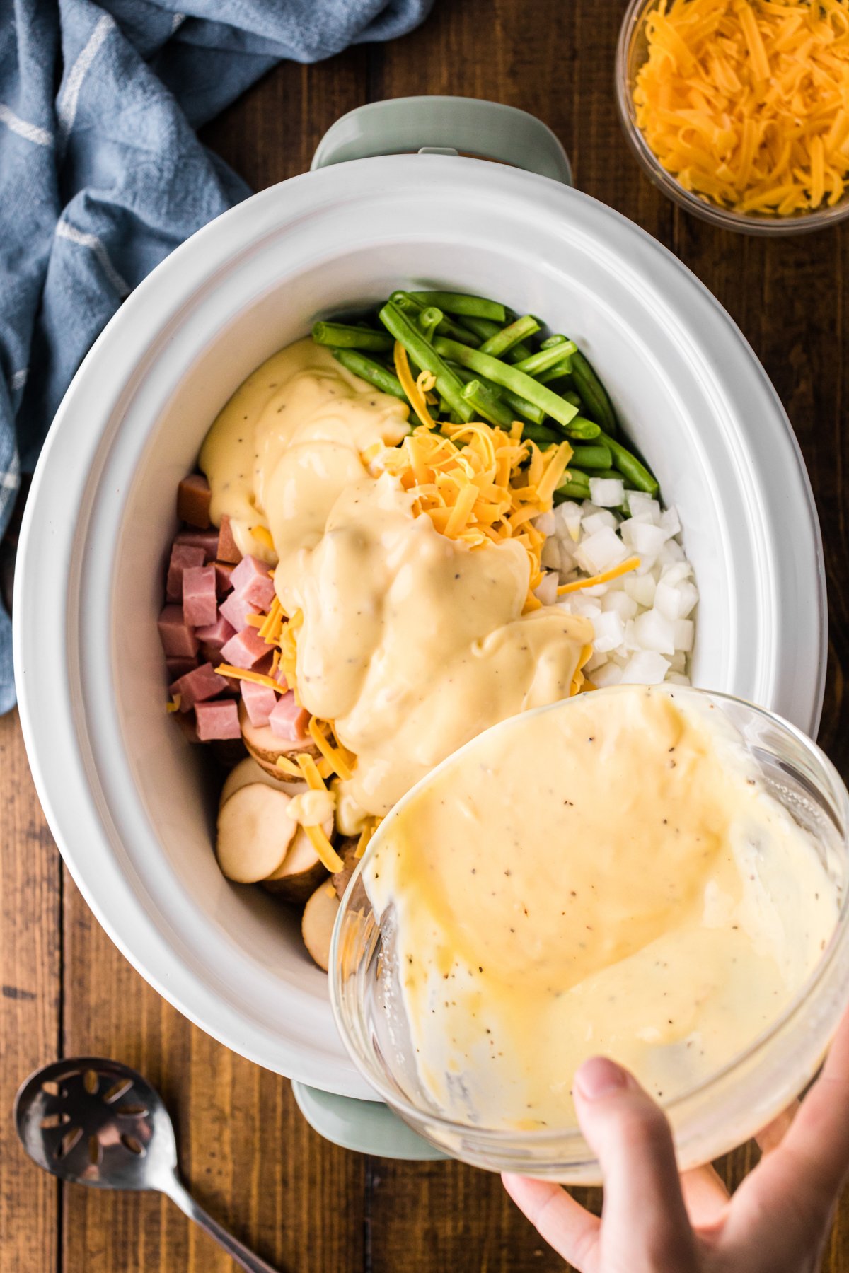 Pouring cream soup mixture into a crockpot.