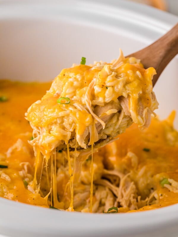 A spoonful of chicken and rice casserole being pulled from a crockpot.