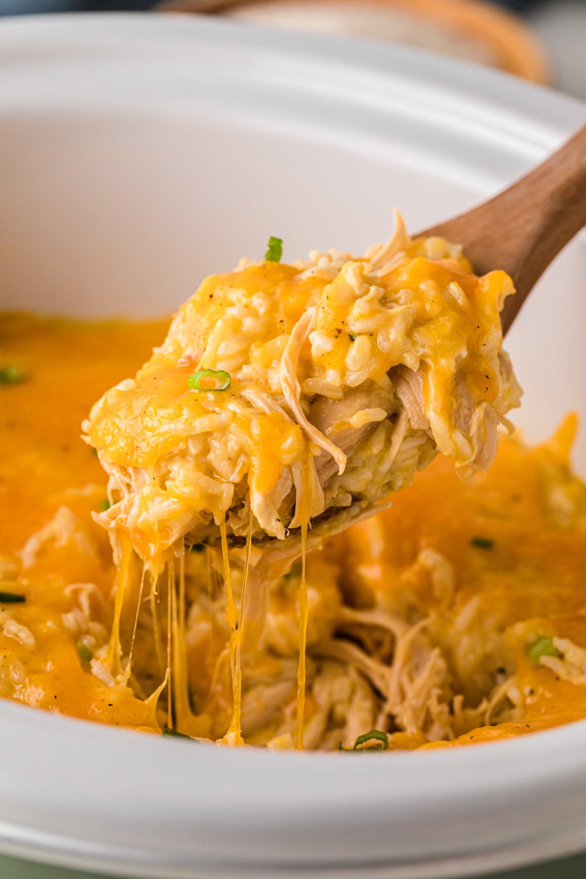 A spoonful of chicken and rice casserole being pulled from a crockpot.