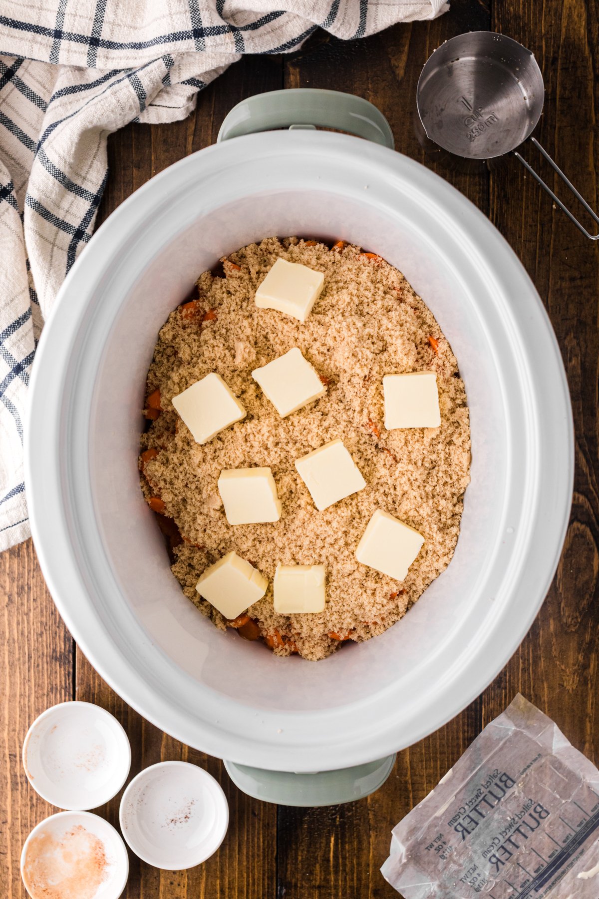 Brown sugar and butter on top of sliced carrots in a slow cooker.