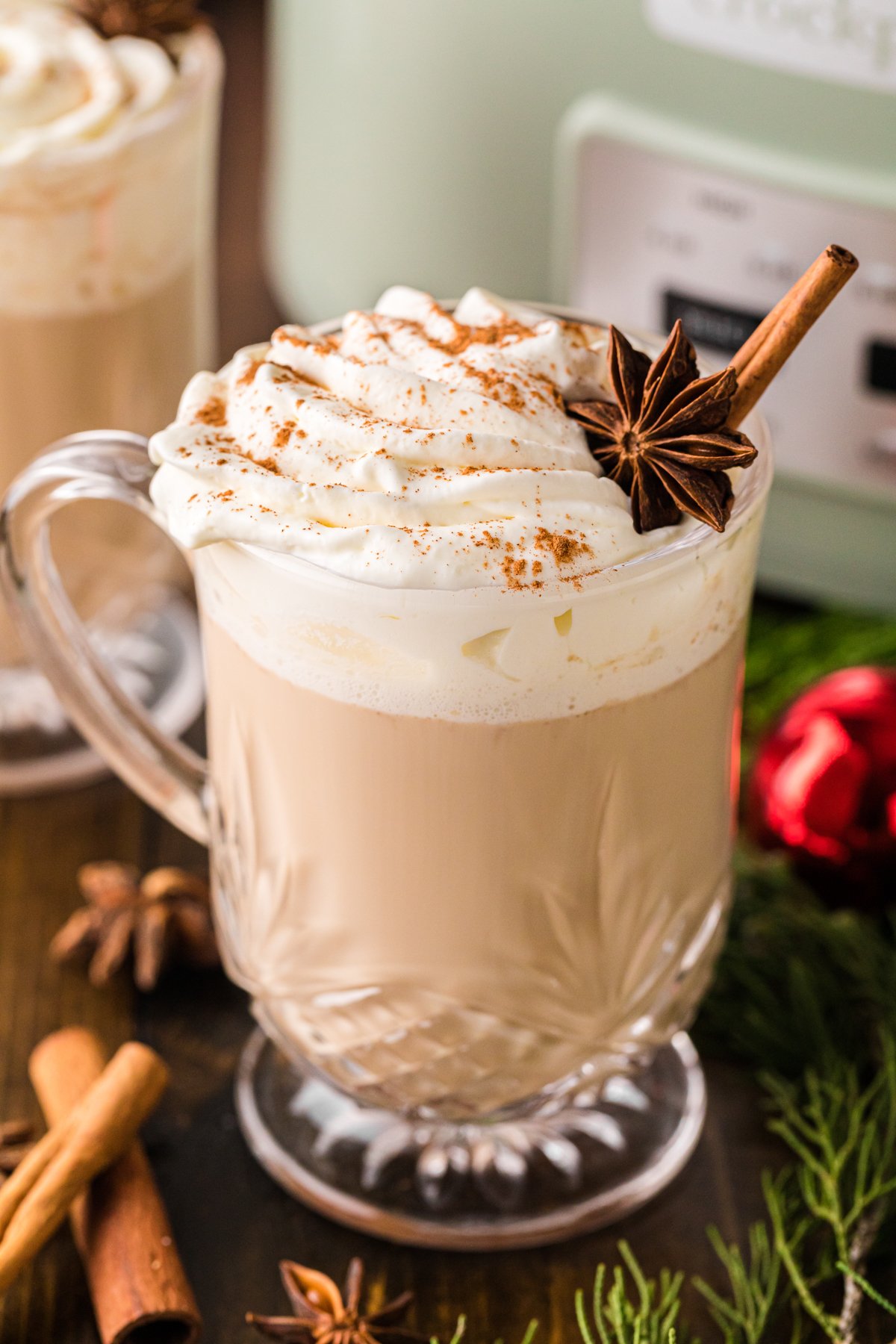 Christmas coffee in a glass mug with whipped cream.