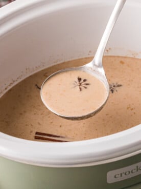A ladle filled with spiced coffee over a crockpot.