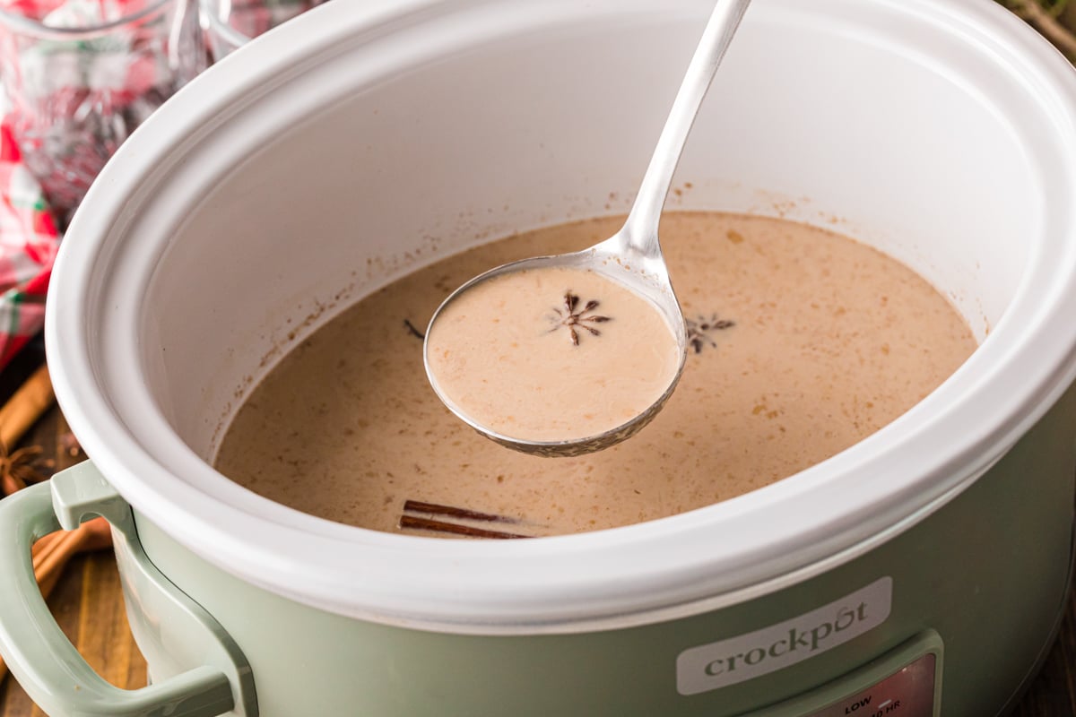 A ladle filled with spiced coffee over a crockpot.