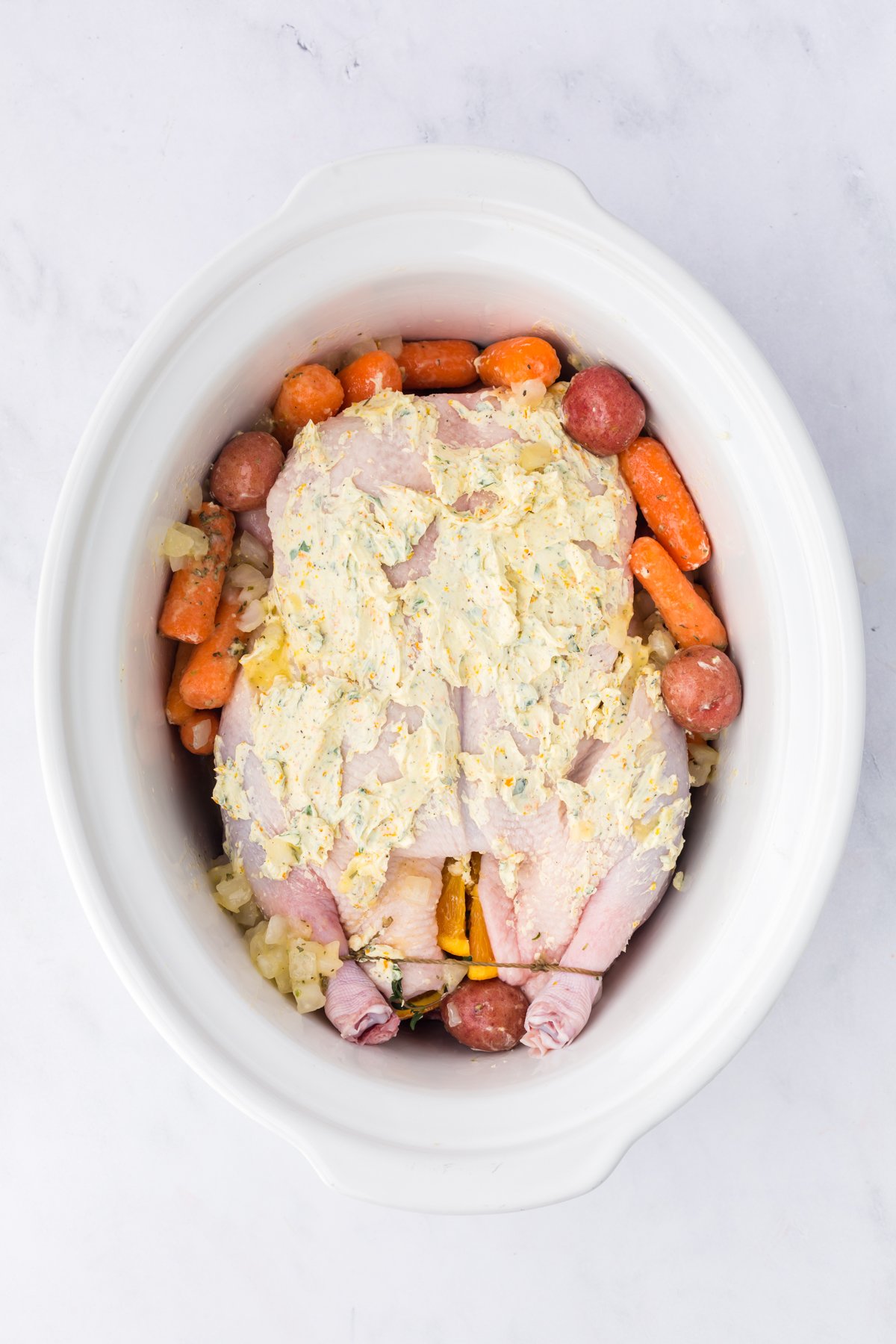 Veggies and a whole duck in a crockpot.