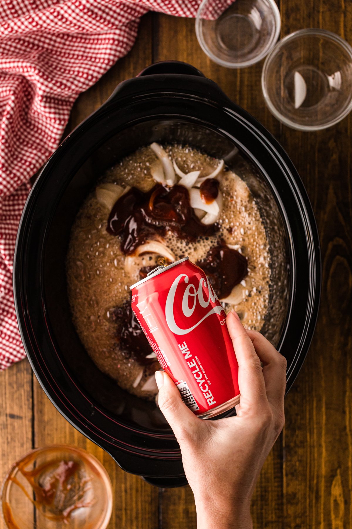Pouring coca cola into a slow cooker.