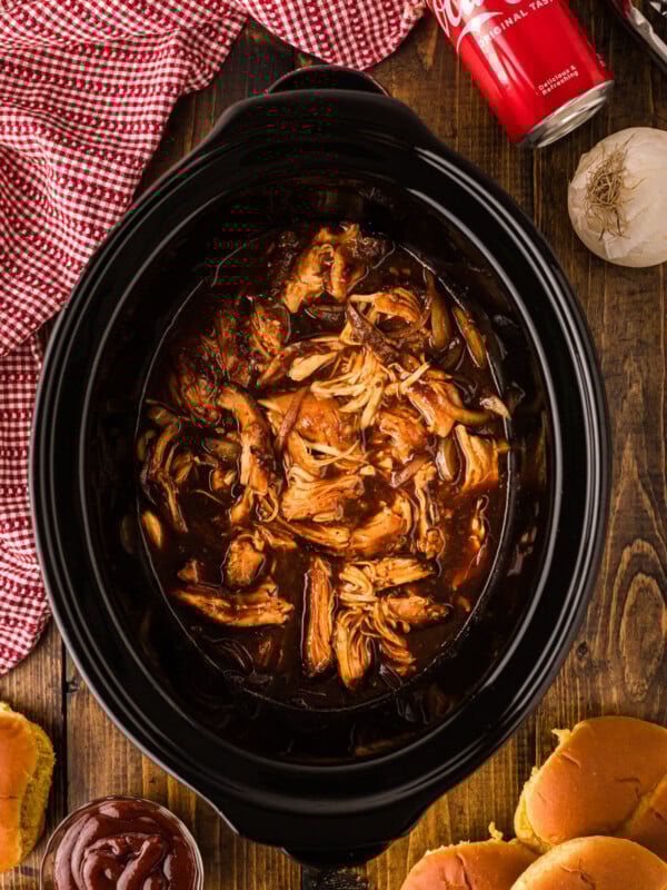 Coca cola chicken in a crockpot after cooking and shredding.