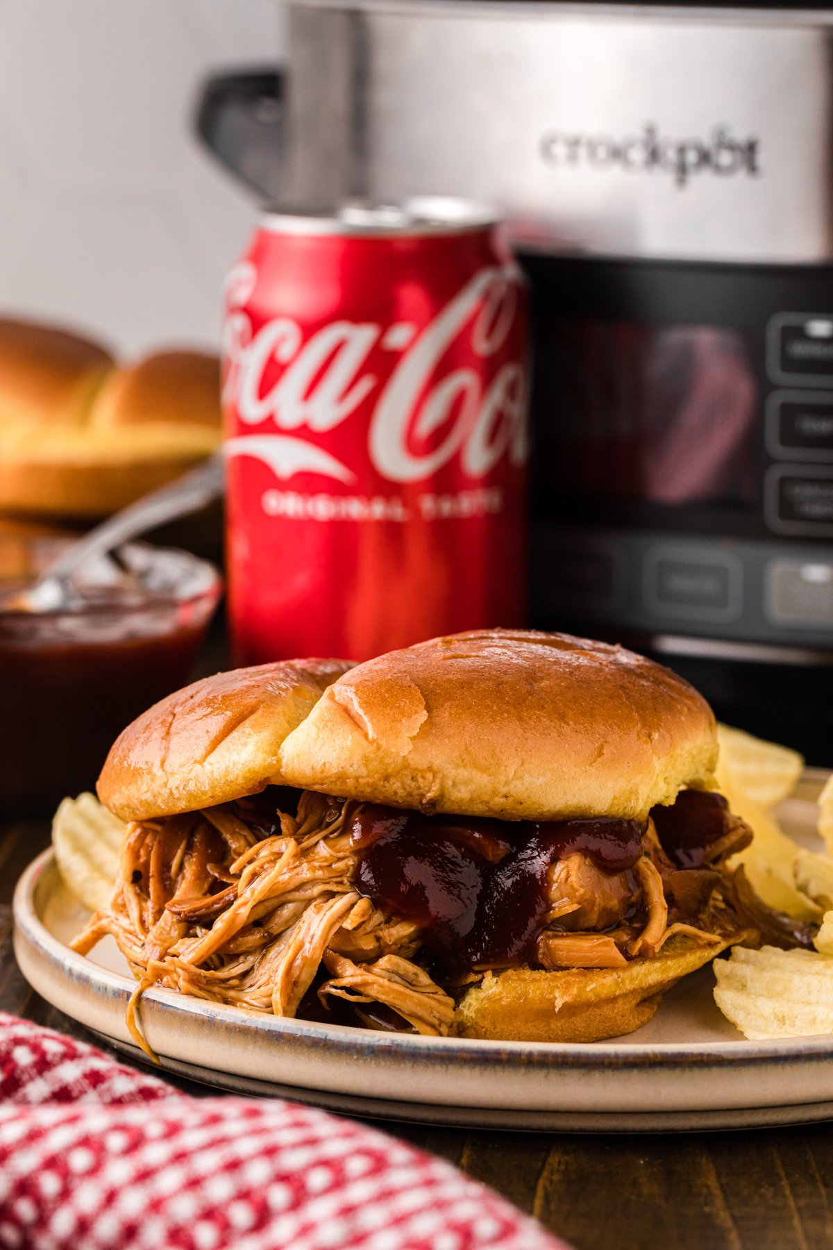 chicken sandwich with coca cola in front of a slwo cooker.