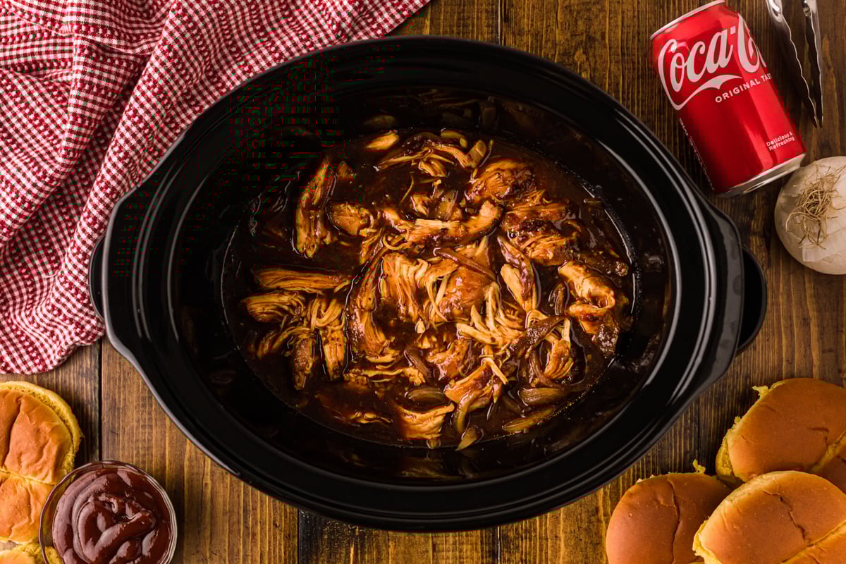 Shredded coca cola chicken in a slow cooker.