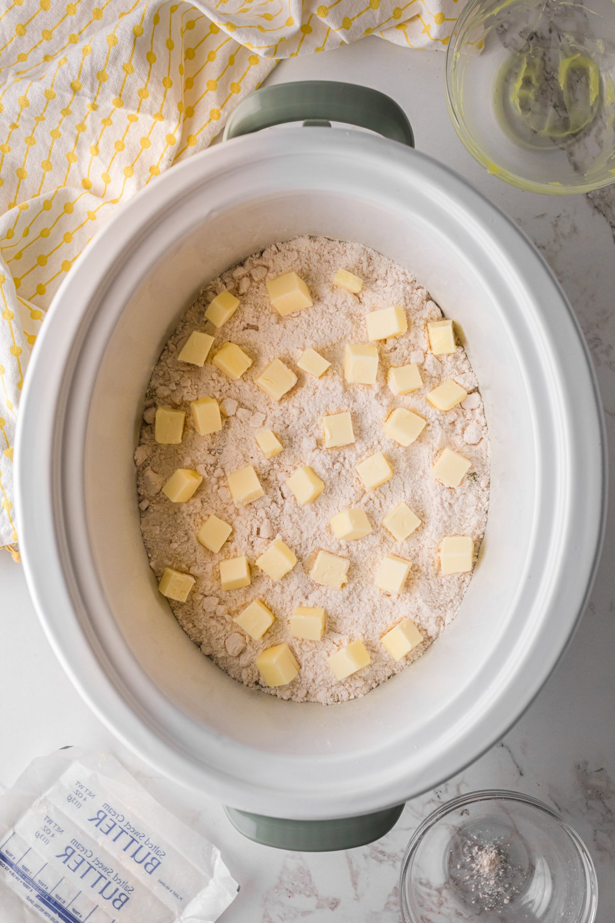 Cubed butter on top of cake mix and lemon pie filling.